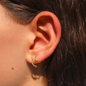 Classic Twirl Earrings in Titanium on model (Gold)