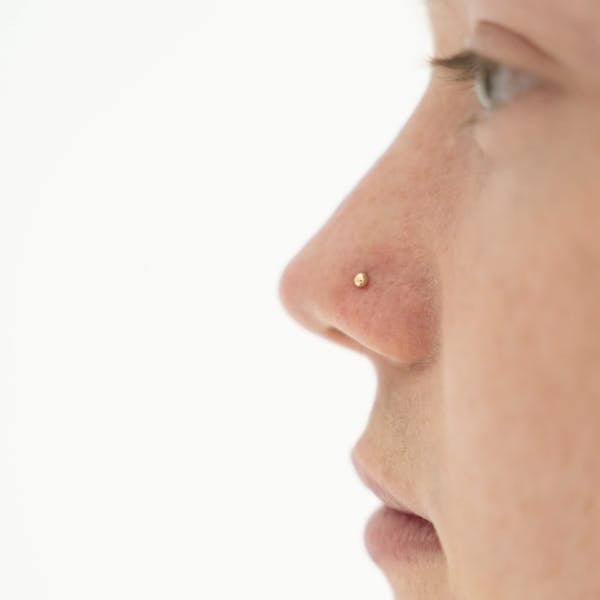 Tiny Secret Stud L-Shape Nose Ring in 14k Gold on model